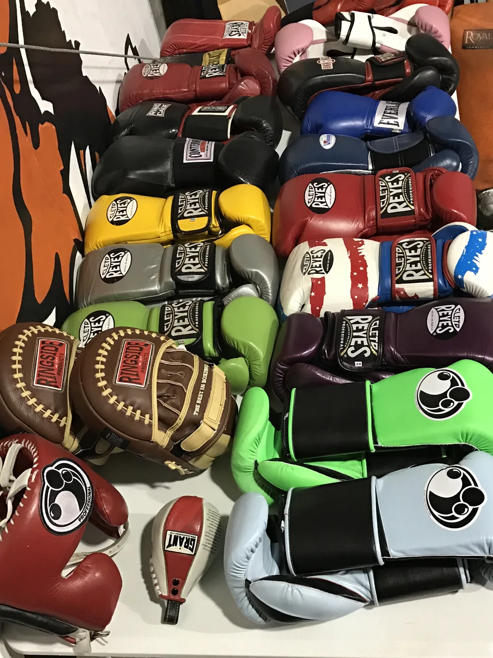 Boxing gloves in every colour laid out together, Cleto Reyes and Ringside pairs among them.